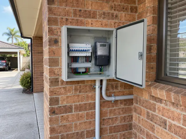 Upgraded exterior switchboard mounted on a brick house wall beside a window in Killarney Vale
